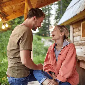 Explore romantic cabin ideas where couples share laughter on rustic porches surrounded by nature