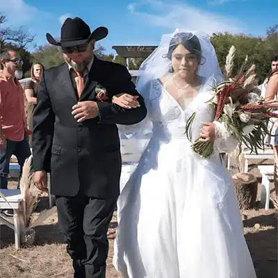 A bride walks down an outdoor aisle in Texas, highlighting the best time to get married in Texas