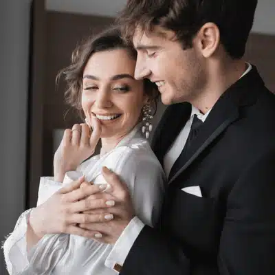 Happy couple embraces lovingly, reflecting what is the purpose of a honeymoon after marriage