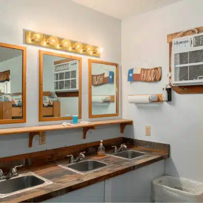 Rustic bathroom with multiple sinks and wooden accents, offering grooms room ideas for weddings