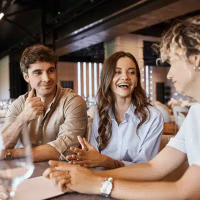 Happy couple meets venue coordinator, discussing reception details while groom gives approving thumbs up today