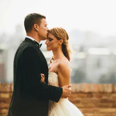 Photo shows bride and groom embracing outdoors, representing ranch wedding venues in texas romantic moment